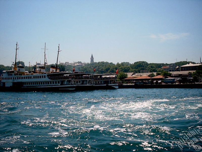 View of Eminonu coast, ships and Topkapi Palace from the sea in Istanbul city of Turkey.
